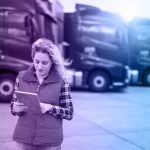 Truck driver holding tablet and checking route for new destination. In background parked truck vehicles. Transportation service.