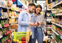 Happy,Couple,Buying,Food,In,Supermarket,,Choosing,Products,Standing,With